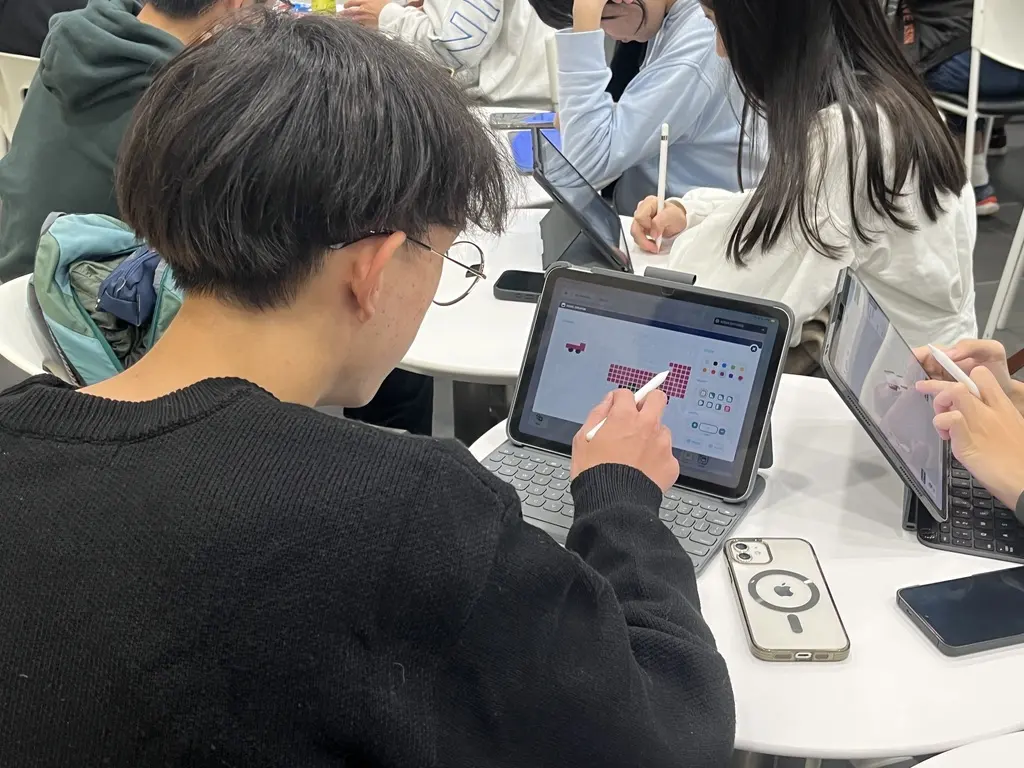 A student designing a pixel model on an iPad with Apple Pencil
