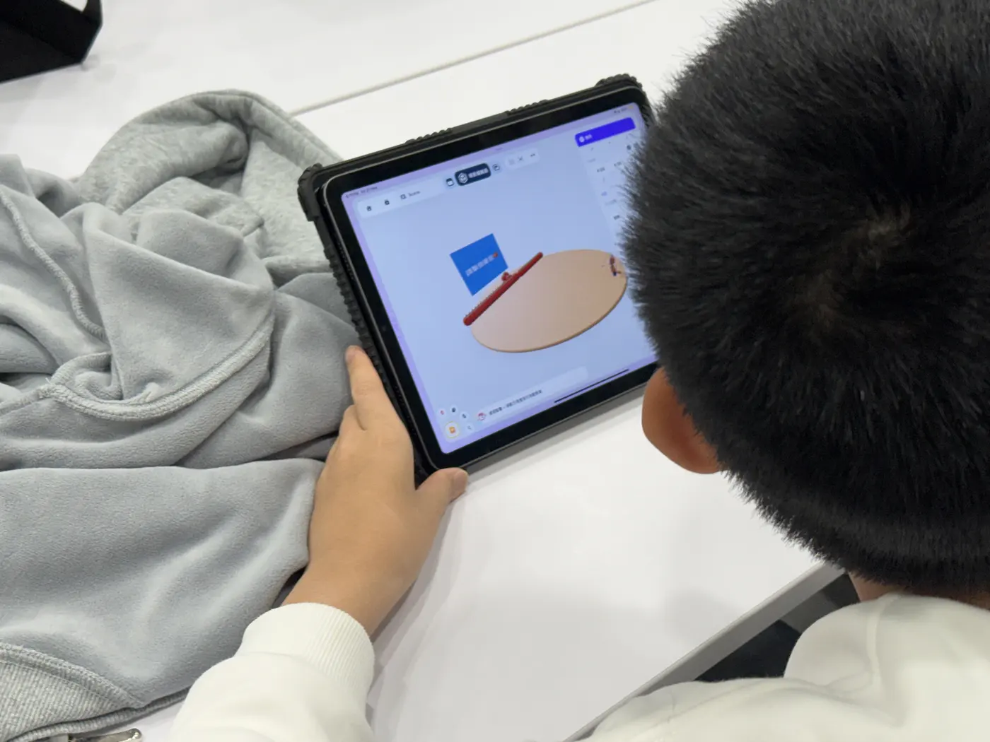 A student adding objects to a scene on an iPad